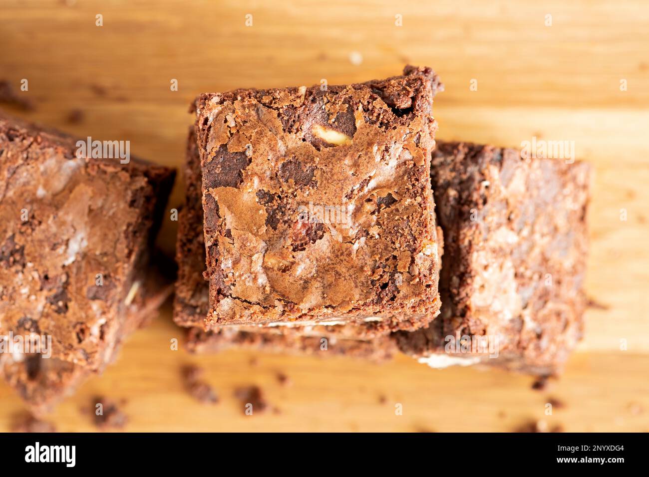Ein Blick von oben auf hausgemachte Chocolate Pecan Brownies auf einer Holzplatte. Die Blondinen sind immer noch warm und klebrig. Ein Genuss Stockfoto