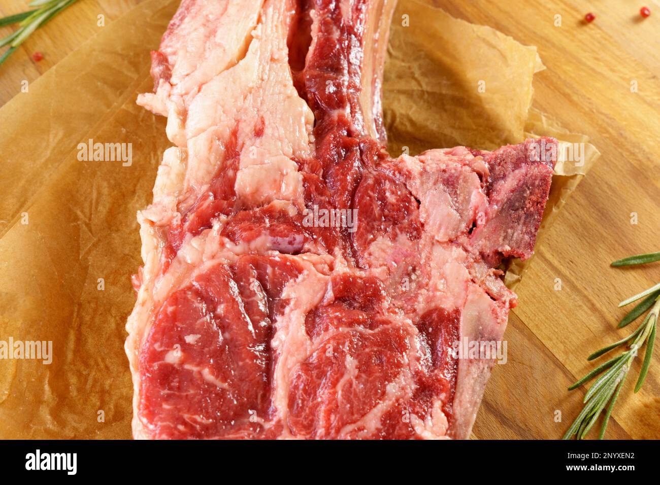 Rohes Cowboy-Steak auf Holzhintergrund, Prime Rib Eye auf Knochen Stockfoto