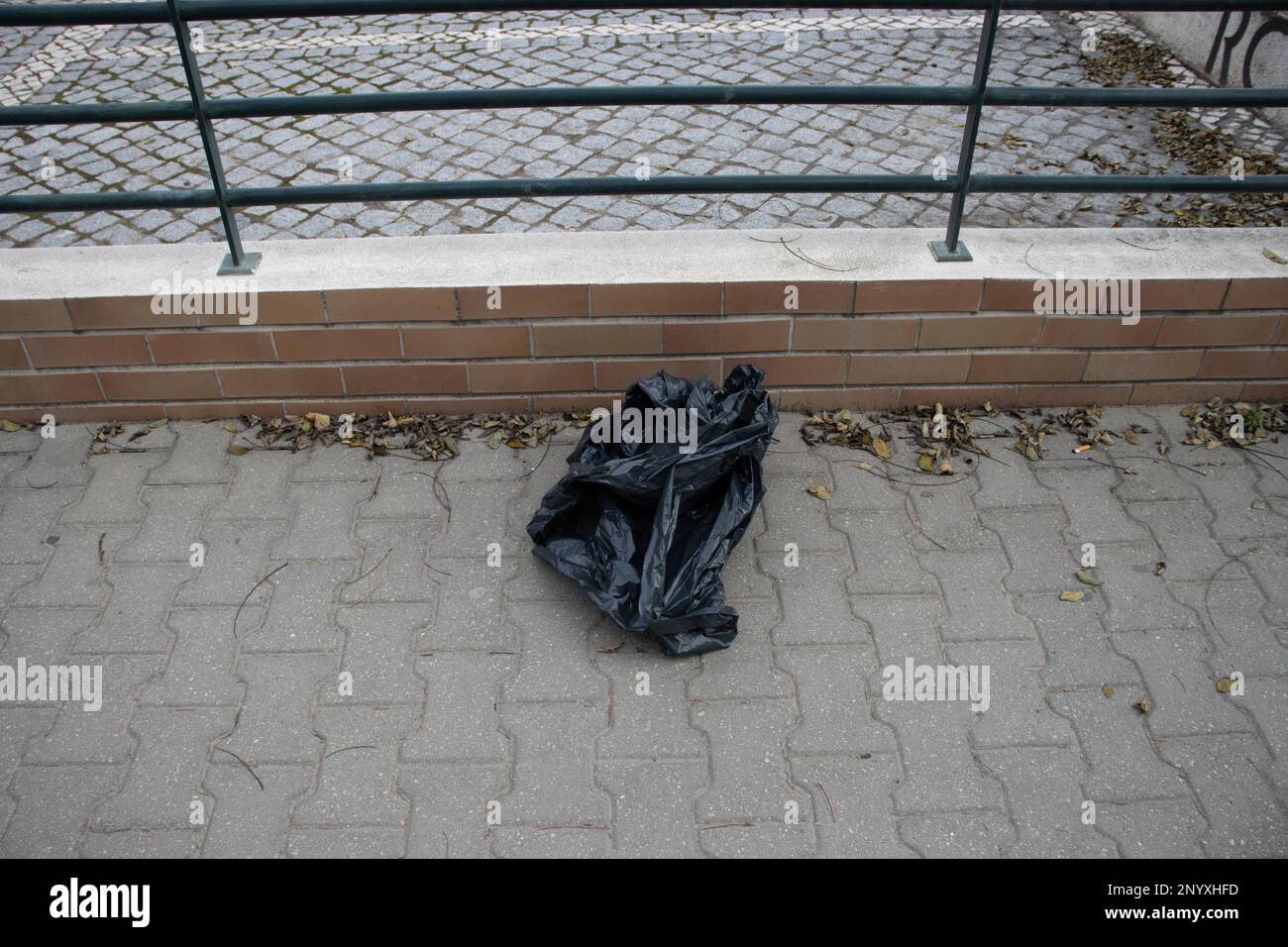 Schwarzer Plastiksack für Müll, der auf der Straße abgeladen wurde Stockfoto