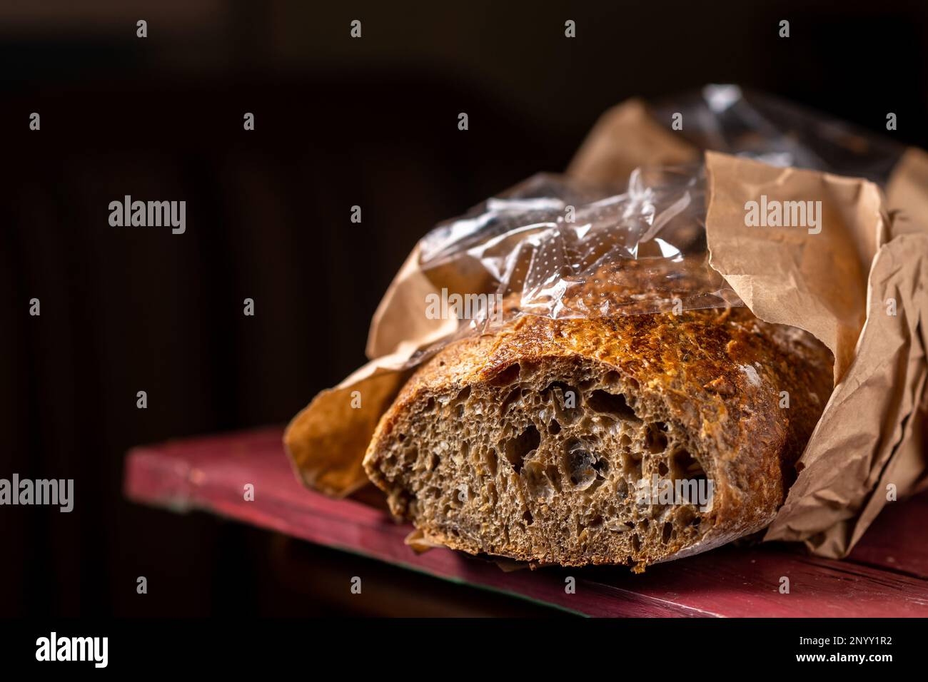 Buchweizenbaguette. Geschnittenes Baguette aus dunklem grobem Mehl. Dunkler Hintergrund. Stockfoto