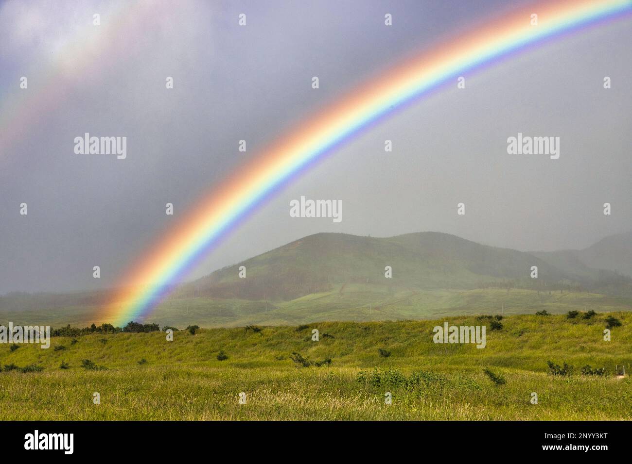 Wunderschöner Regenbogen, der die Berge von West maui umgibt. Stockfoto