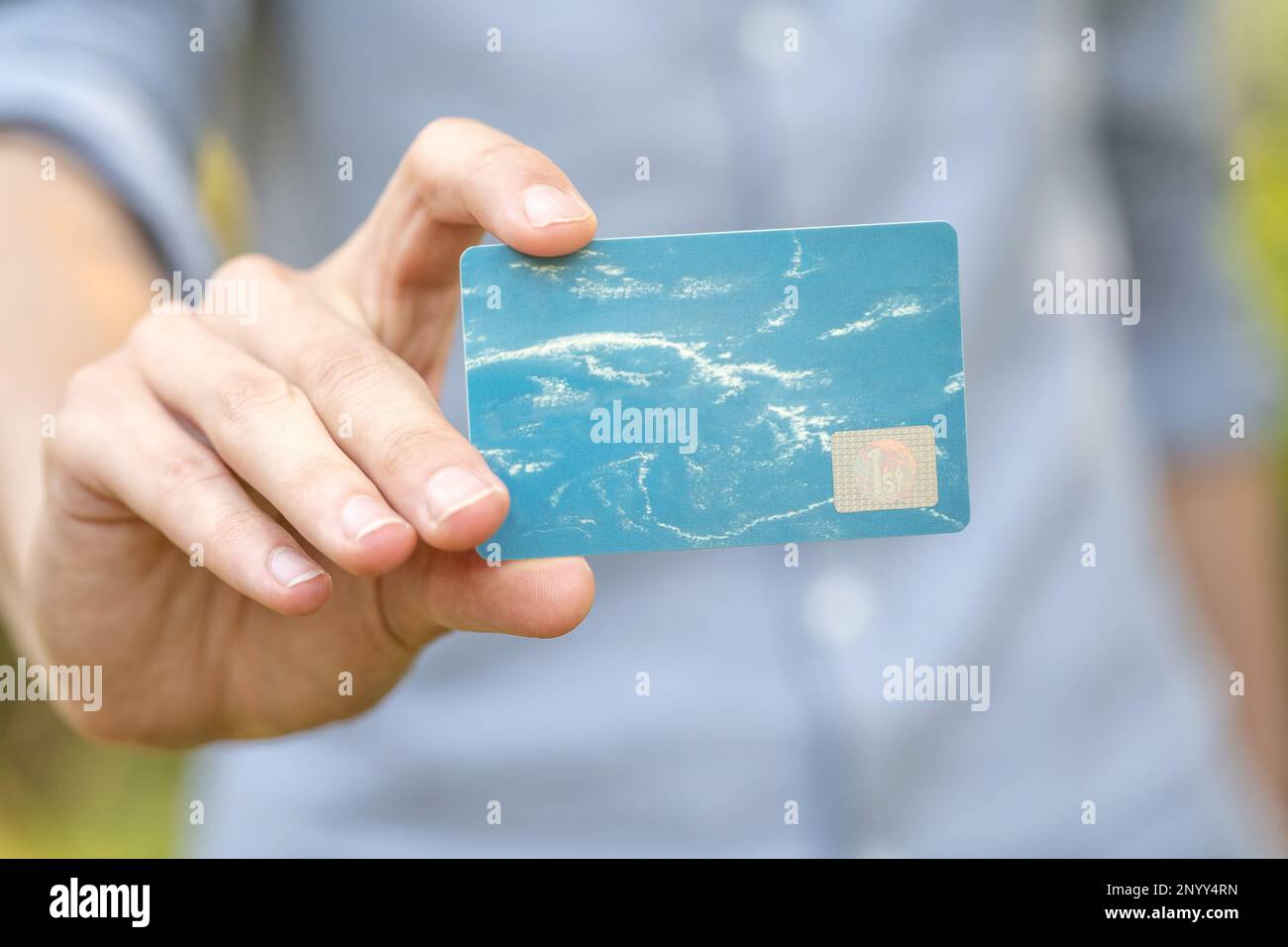 Ein Mann mit einer blauen Premium VIP Social Club-Mitgliedskarte in der Hand, leere Vorlage, Modell, Wolken, Kopierbereich, Kartenobjekt-Nahaufnahme, eine pro Stockfoto