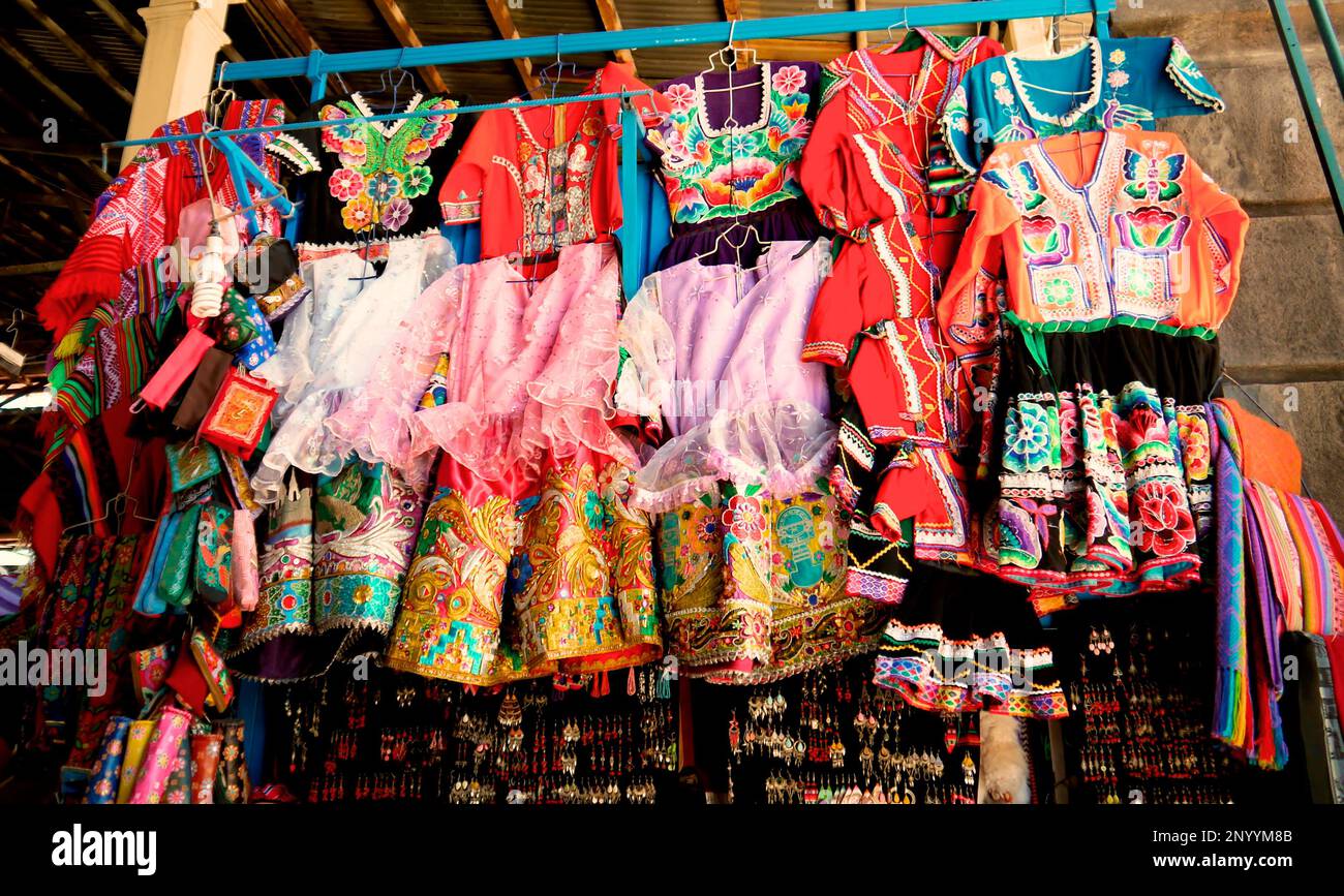 Bunte Partykleidung für Kinder wird auf dem öffentlichen Markt in Cusco Peru ausgestellt Stockfoto