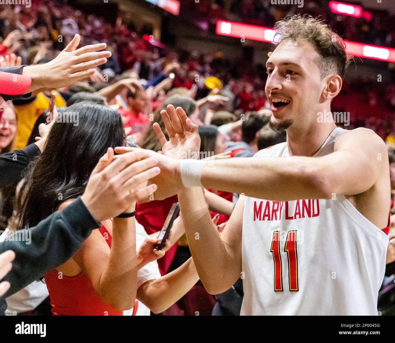 College Park, Maryland, USA. 26. Februar 2023. Noah Batchelor (11) von der University of Maryland feiert mit Fans nach dem Sieg auf Platz 21 der Northwestern U Stockfoto