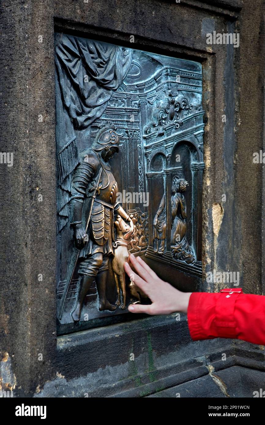 Karlsbrücke. Touristischen berührt für Goodluck das Relief, das an den Füßen die Statue des Hl. Johannes de Nepomuk.Prague hat. Tschechische Republik Stockfoto