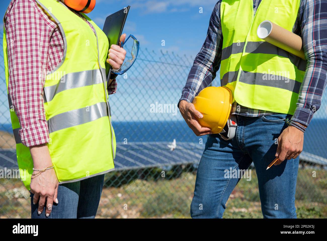 Nahaufnahme der Körper zweier Ingenieure mit reflektierender Weste und Werkzeugen Stockfoto