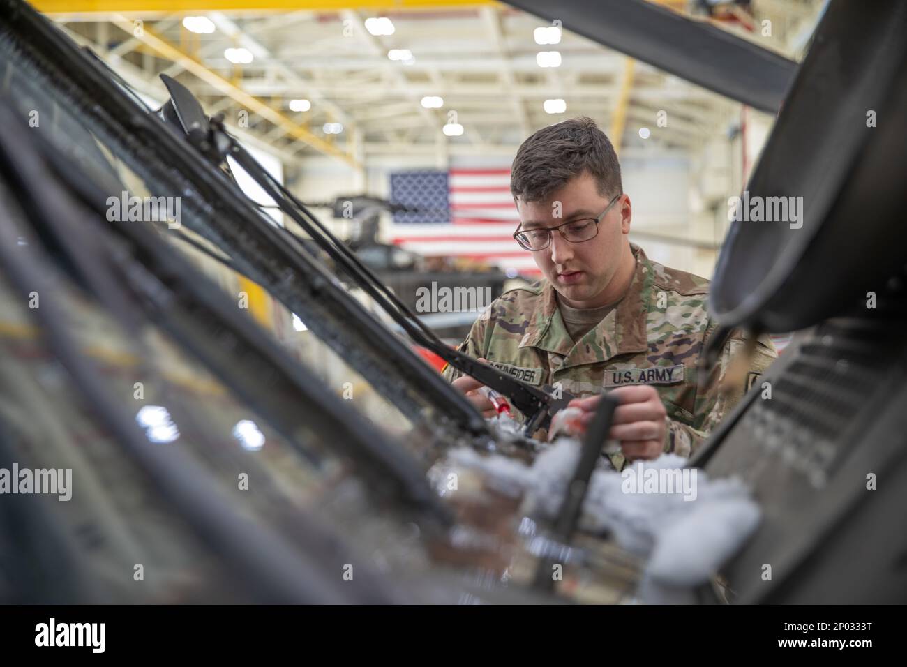 SPC. Justin Schneider, ein UH-60-Hubschrauberreparaturbetrieb, Delta Company, 3. Bataillon, 238. Aviation Regiment (MEDEVAC), schmiert die Getriebe der Scheibenwischer eines Black Hawk während der Routinewartung in der NH National Guard Army Aviation Support Facility, Concord, am 7. Januar. Schneider sprach über die Bedeutung ihrer Routine- und Präventivarbeit sowie über die Tiefen, bis zu denen sie diese Hubschrauber betreuen. „So einfach wie die Scheibenwischer können große Probleme verursachen“, so Schneider. „Wenn diese aufhören, können wir nicht fliegen, also ist es meine Aufgabe, dafür zu sorgen, dass das nicht passiert.“ Stockfoto