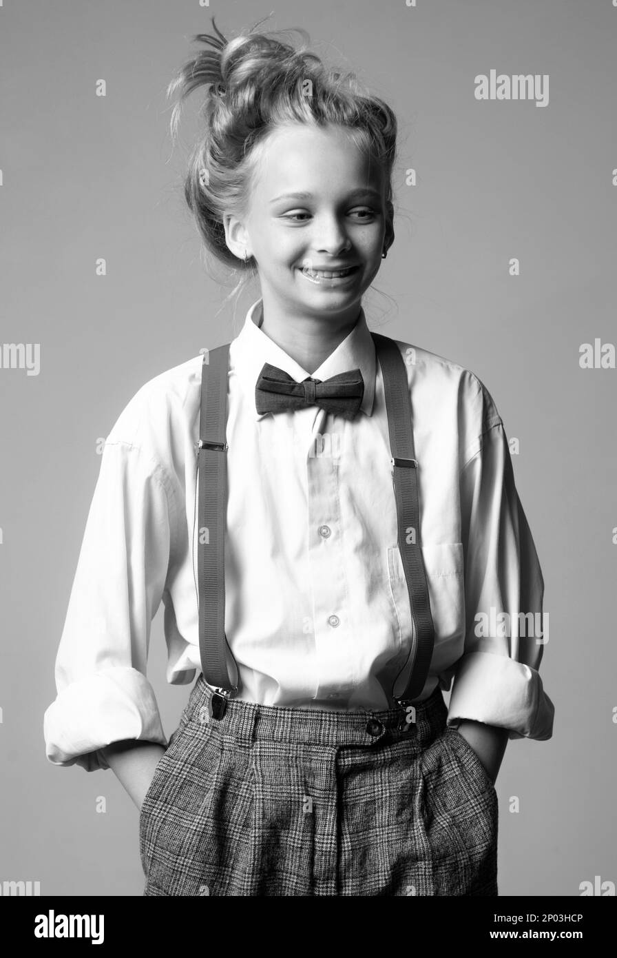 Style in Aktion. Teenager im Männeranzug im Retro-Look. Retro-Modemodell. Klassische charleston-Party. Klassischer englischer Stil. Hosenträger und Fliege. Alt Stockfoto