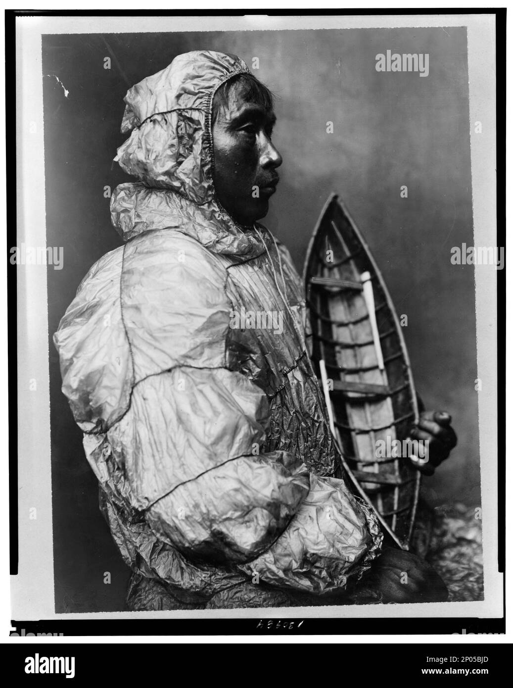 Kajakfahrer trägt eine wasserdichte Jacke mit einem Spielzeugboot, das er für seinen Sohn gemacht hat. Frank and Frances Carpenter Collection , Gift; Mrs. W. Chapin Huntington; 1951, Eskimos,Clothing & Dress,Alaska,1890-1940, Indians of North America,Clothing & Dress,Alaska,1890-1940, Kajaks,1890-1940, Toys,1890-1940, United States,Alaska Stockfoto