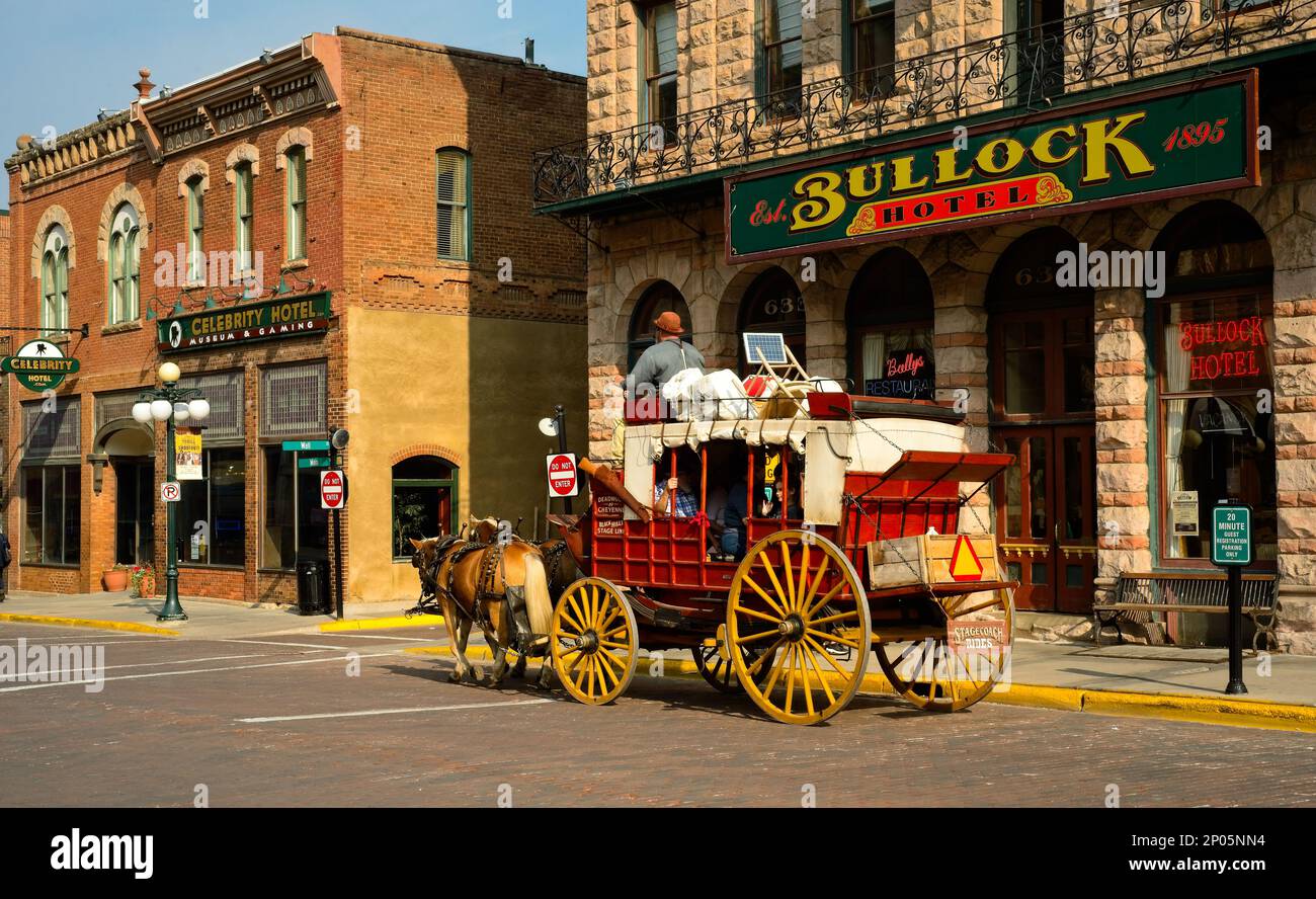 Eine altmodische Postkutsche bringt Touristen vorbei am alten Bullock Hotel auf der Main Street in der Goldgräberstadt Deadwood, South Dakota. Stockfoto