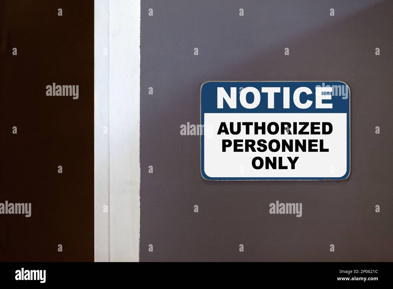 Blau-weißes Hinweisschild an der Seite einer offenen Tür mit der Aufschrift „Hinweis, nur autorisiertes Personal“. Stockfoto