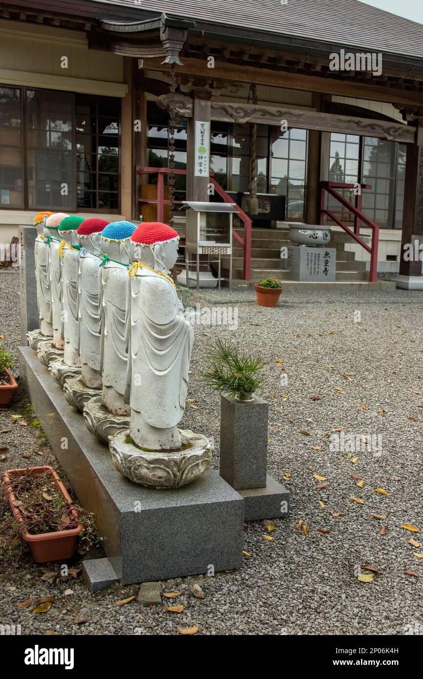 Jizoo-Statuen, Jünger Buddhas, im Jingui-Tempel mit gestrickten Hüten und Lätzchen (Kasa), Kamiyama, Japan Stockfoto