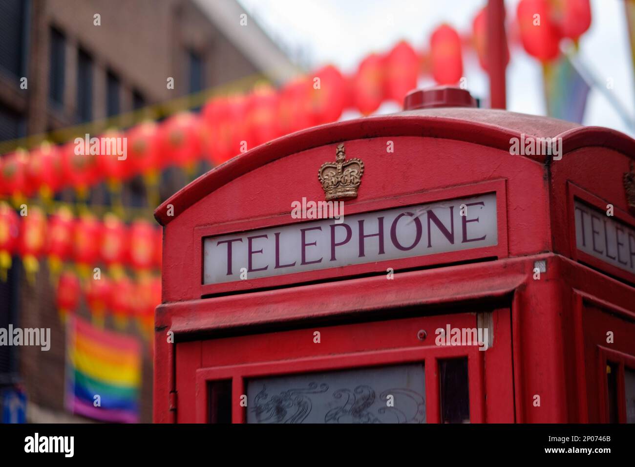 Telefonzelle in Chinatown (Soho), mit LGBT-Flagge im Hintergrund Stockfoto