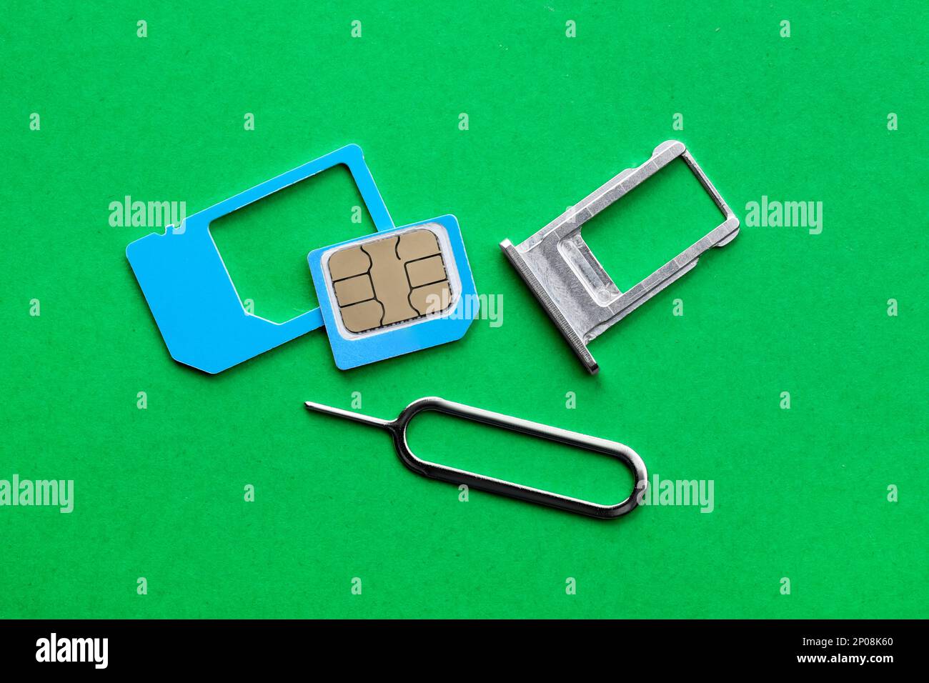 SIM-Karte, Einschub und Auswerfer auf grünem Hintergrund, flach aufgelegt Stockfoto