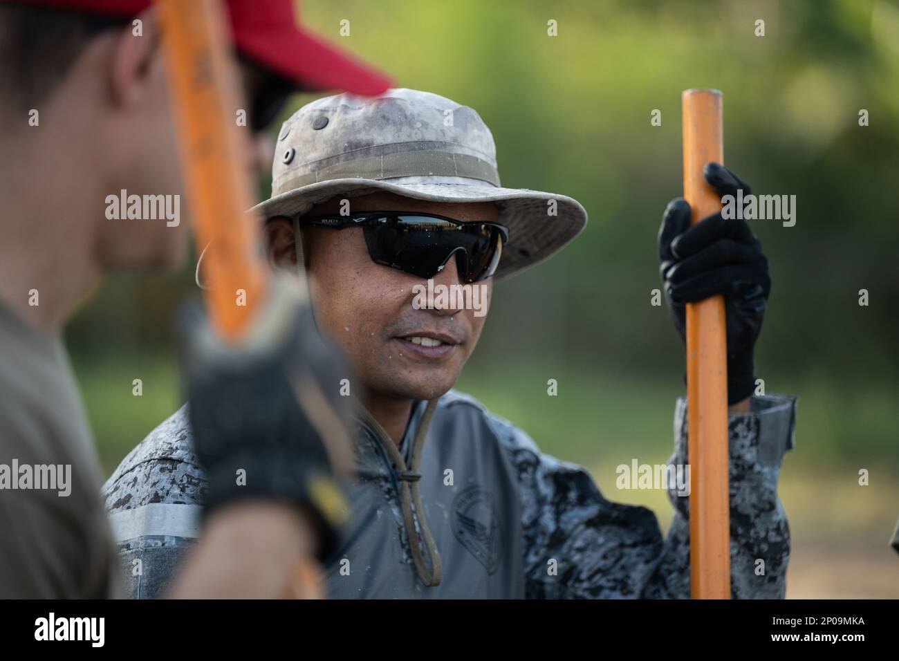 Ein Mitglied der philippinischen Luftwaffe spricht mit einem Mitglied der 819. Red HORSE Squadron, während es darauf wartet, Beton im Rahmen eines Feldtrainings am Basa Air Base, Philippinen, am 25. Januar 2023 zu gießen. Veranstaltungen wie diese zeigen die USA Das Engagement der Luftwaffe, die Verteidigungsfähigkeiten ihrer Alliierten und Partner zu verbessern, und die internationalen Fluggesellschaften bilden das Rückgrat dieser Partnerschaften zwischen Militär und Militär. Stockfoto