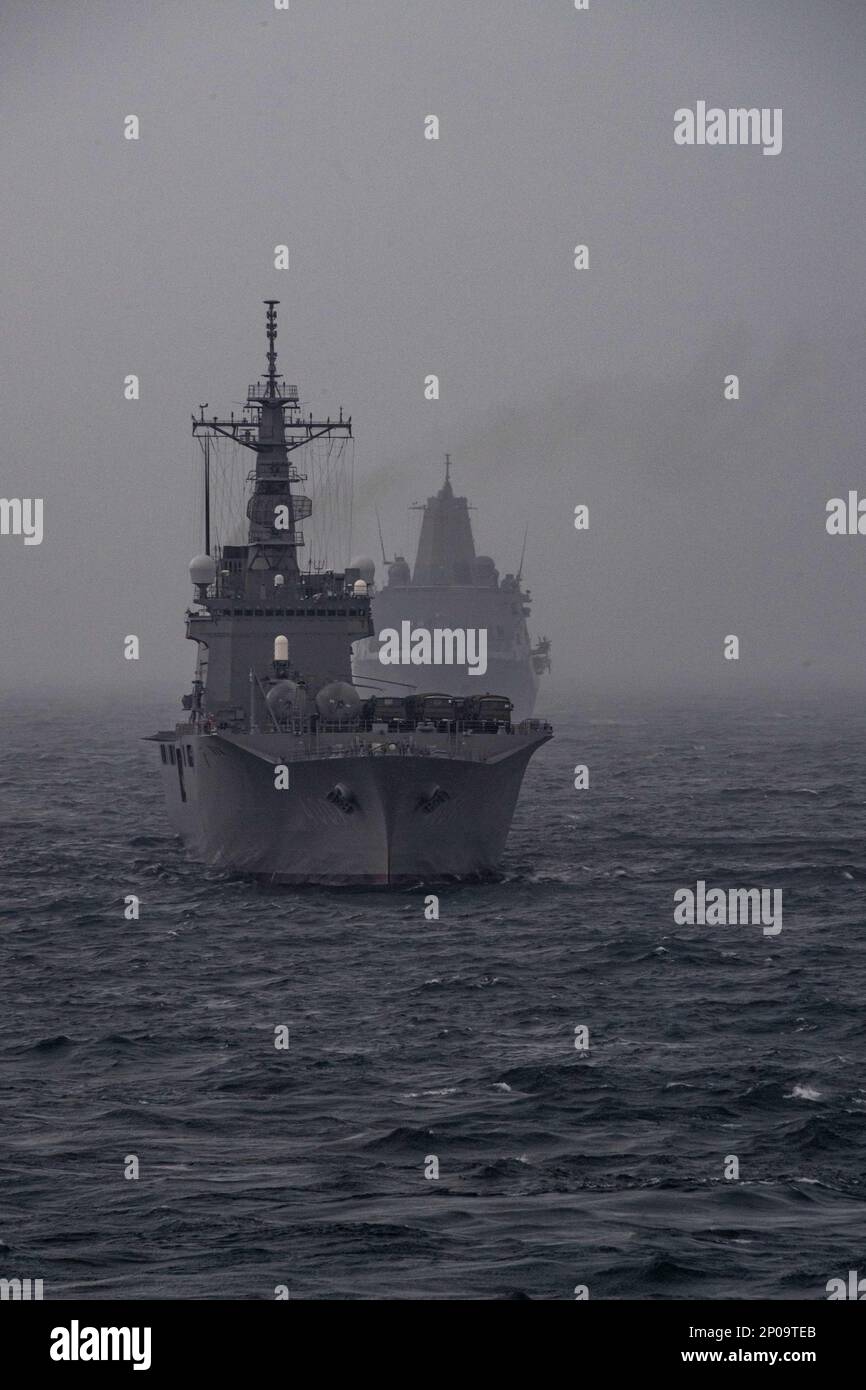 OSTCHINESISCHES MEER (1. März 2023) Japan Maritime Self-Defense Force Landeschiff Panzer JS Osumi (LST 4001), vorne, Und Amphibienschiff USS Green Bay (LPD 20), zurück, segeln Sie in Formation mit dem nach vorn eingesetzten Amphibienschiff USS America (LHA 6), während einer Antiminenübung im Rahmen der Übung Iron Fist während des Segelns im Ostchinesischen Meer, März 1. Iron Fist ist eine jährliche bilaterale Übung, die darauf abzielt, die Interoperabilität zu erhöhen und die Beziehungen zwischen den USA zu stärken Marine Corps, die USA Navy, die Japan Ground Self Defense Force und die Japan Maritime Stockfoto