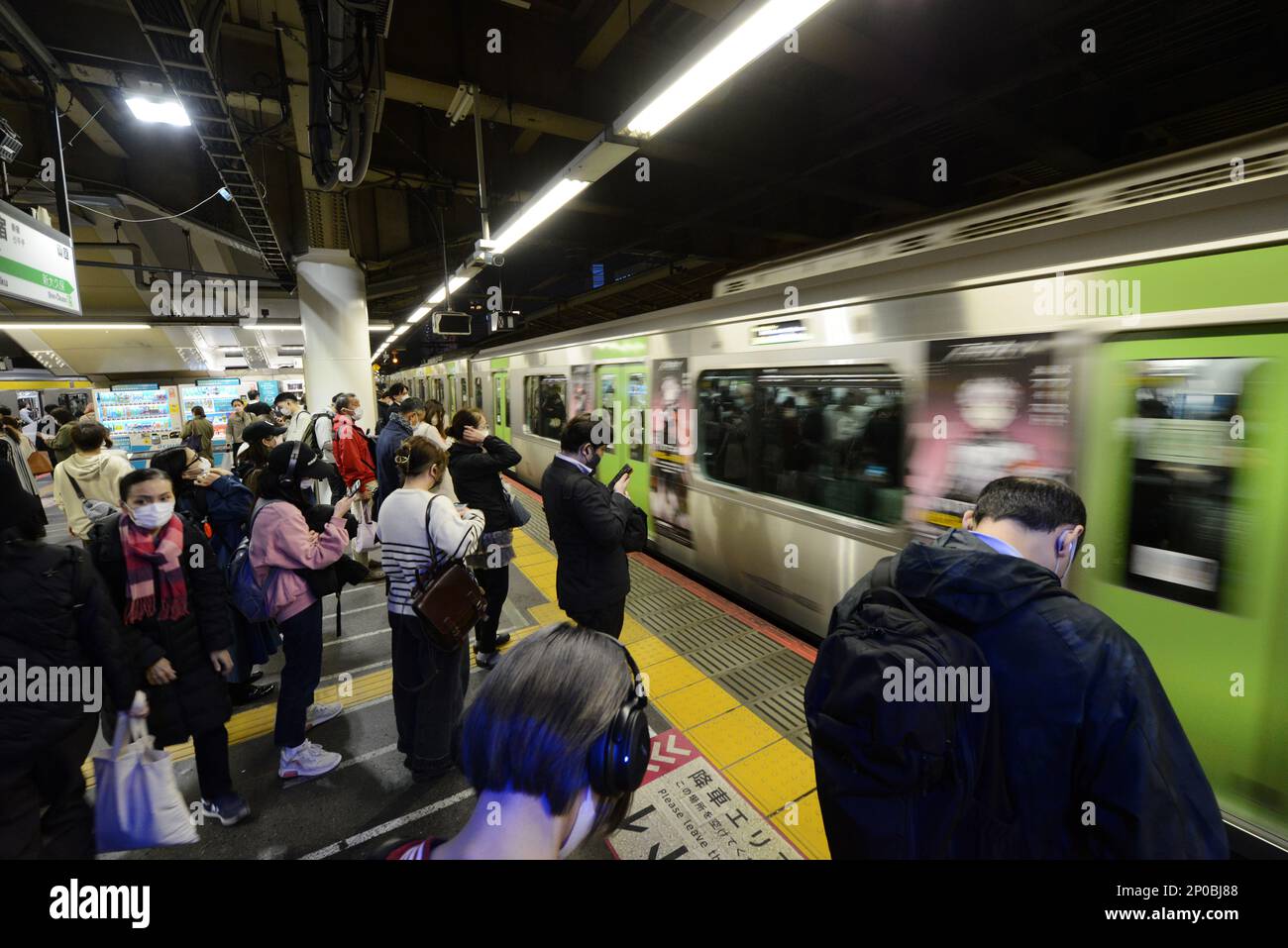 Japanische Passagiere warten auf die JR Yamanote-Linie in Tokio, Japan. Stockfoto