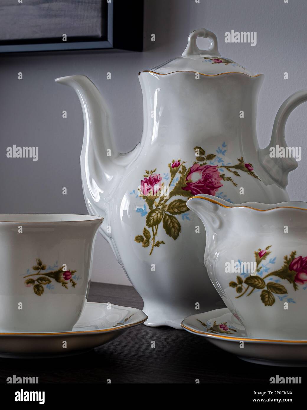 Porzellangeschirr, Kaffee- oder Teetasse. Tee- oder Kaffeekanne und Zuckerdose. Handbemalte Blumen. Kann zur Veranschaulichung von Porzellan in Zeitungen verwendet werden. Stockfoto