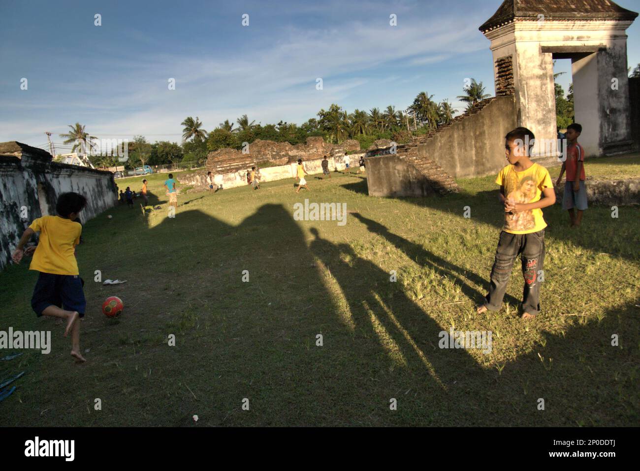 Flache Grasfelder zwischen den Ruinen sind beliebte Orte für Kinder, um Fußball zu spielen im Kaibon Palast, eines der Kulturerbe-Objekte der Banten Sultanate-Zeit, das sich in der Gegend befindet, die heute Banten Lama (Old Banten) in Serang, Banten, Indonesien heißt, auf diesem Foto, das 2010 aufgenommen wurde. Eine kürzlich von Nurikah und E. Rakhmat Jazuli (Fakultät für Recht, Sultan Ageng Tirtayasa Universität, Banten) durchgeführte Feldforschung hat ergeben, dass es zahlreiche Verstöße gegen die Behandlung von Kulturerbeobjekten in der Region gab. Die Menschen üben sportliche Aktivitäten in der Umgebung von Kulturerbeobjekten aus, Stockfoto