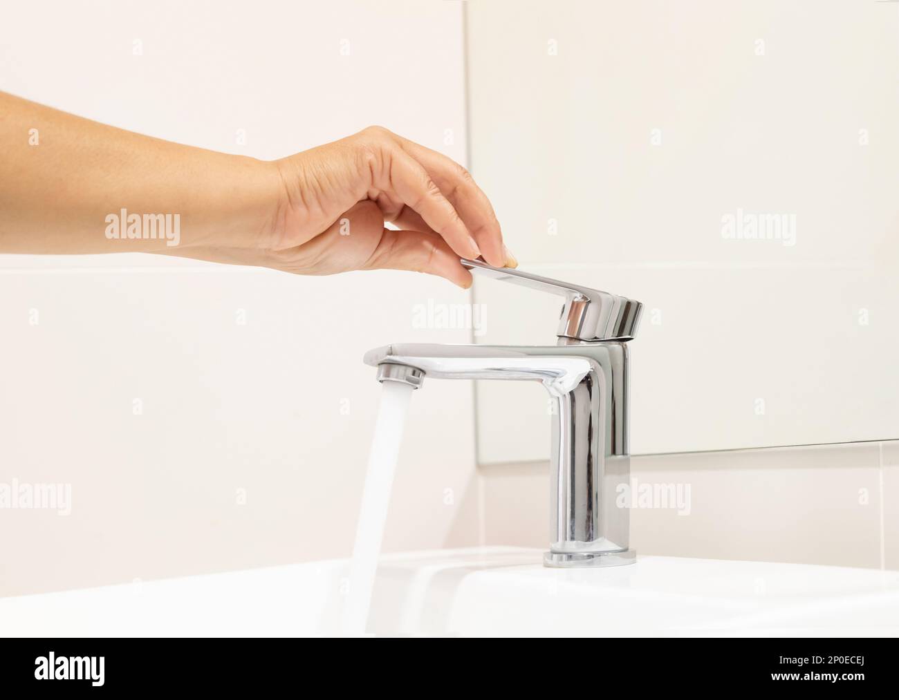 Schließen Frau öffnen Pull Chrom Wasserhahn Waschbecken zum Waschen Hand Seife für Corona Virus am Wasserhahn. Den fließenden Wassertropfen abdrücken. Badezimmer Stockfoto