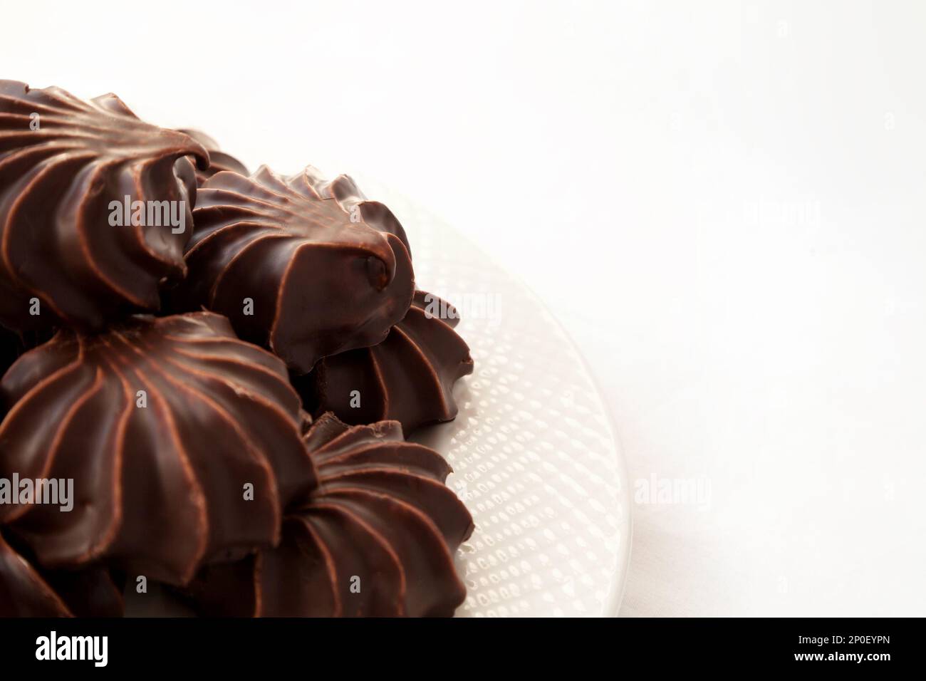 Haufen von Marshmallows mit Schokolade glasiert. Viele beschichtet elegante Zephyr Dessert isoliert auf weiss. Elegante Süßspeise auf einem Teller Stockfoto