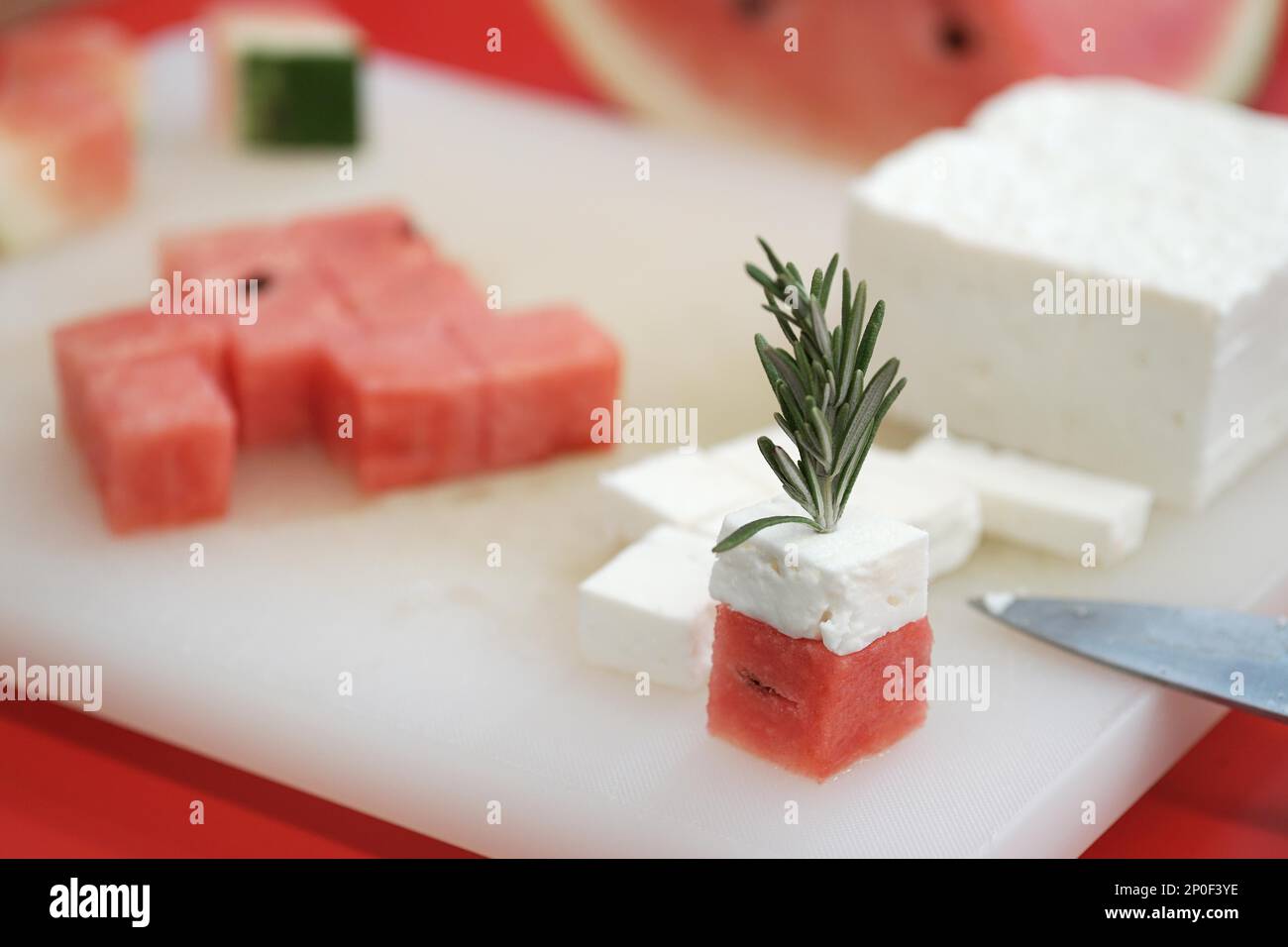 Wassermelone und Fetakäsewürfel mit Rosmarin. Authentische griechische Küche mit selektivem Fokus Stockfoto