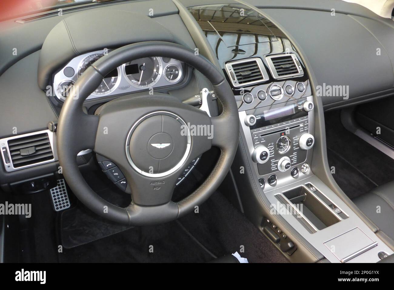 Modernes Aston Martin Cockpit, Instrumententafel, Lenkrad, Lederlenkrad Stockfoto