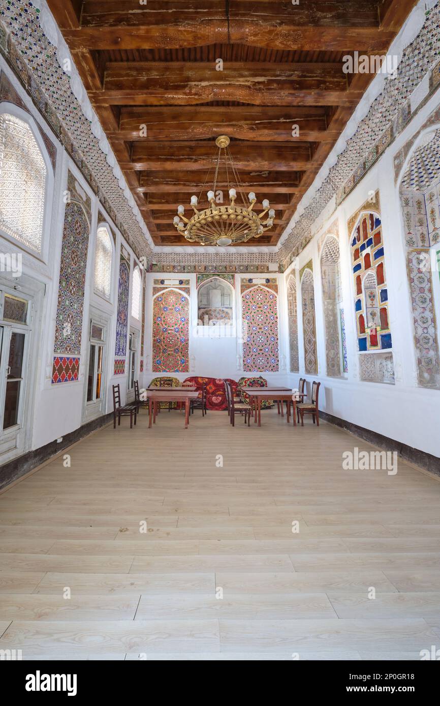 Ein renoviertes großes Wohnzimmer, das jetzt mit Tischen und Stühlen genutzt wird. In einem alten, historischen, klassischen, traditionellen, typischen Ikonisches jüdisches Haus Stockfoto
