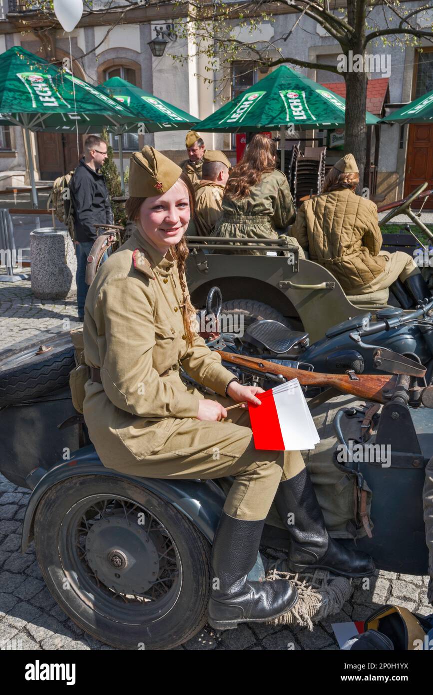 Reenaktorin in sowjetischer Uniform, mit polnischer Flagge, vor der Wiederaufnahme der Schlacht von WW2, Rathausplatz in Jelenia Gora, Niederschlesien, Polen Stockfoto