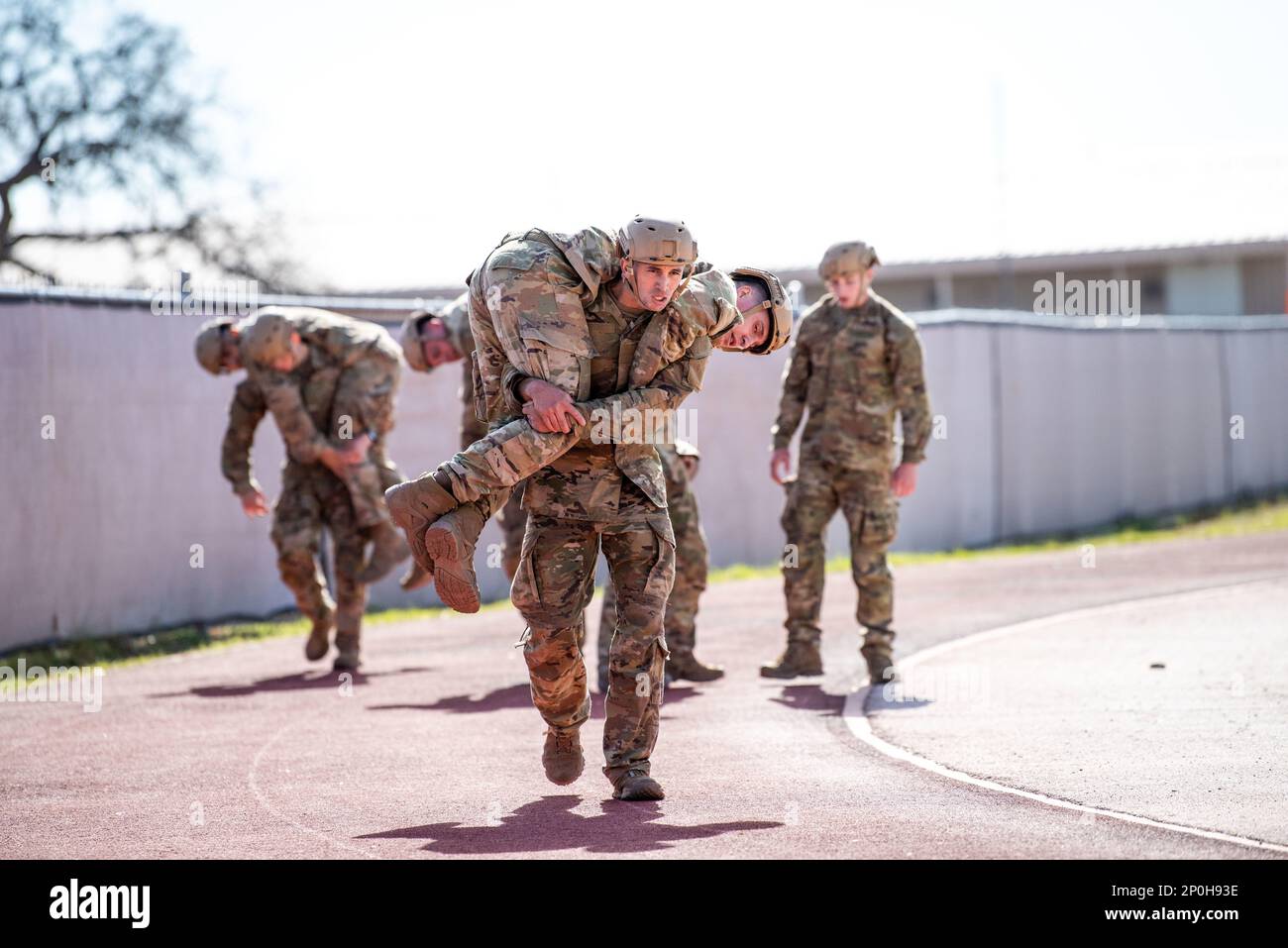 Special Warfare-Kandidaten tragen ihre Teamkollegen im Rahmen des Extended Resiliency Training (PRT) am 26. Januar 2023 auf der Joint Base San Antonio-Lackland. PRT simulierte die stressigen und langen Arbeitszeiten eines Bedieners vor Ort, testete die Ausdauer und die Fähigkeit der Kandidaten, als Team zu arbeiten, und bereitete sie gleichzeitig auf die Härten der bevorstehenden Schulung vor. Stockfoto