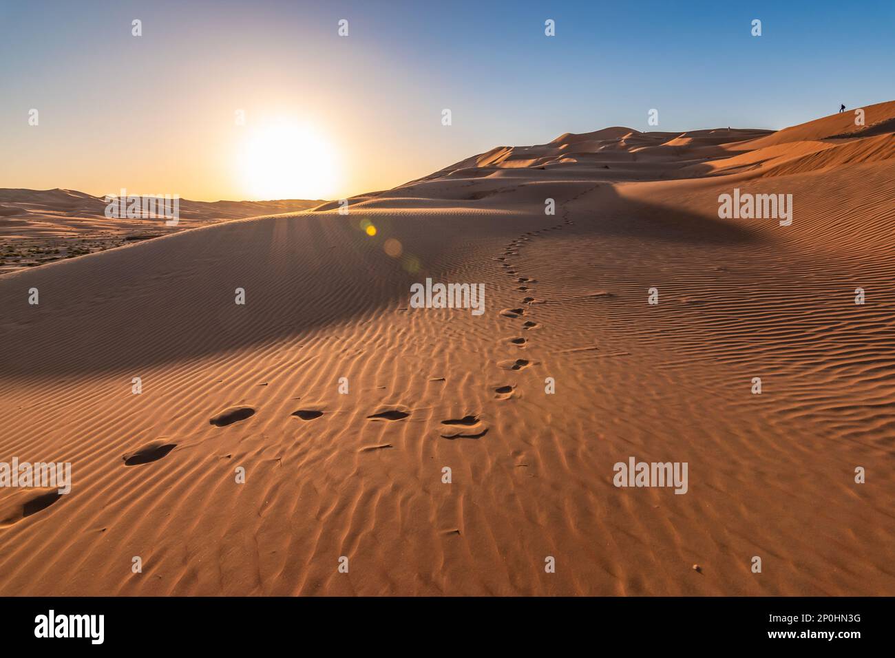 Fußabdrücke in den Sanddünen der Wüste Abu Dhabi bei Sonnenuntergang. Stockfoto
