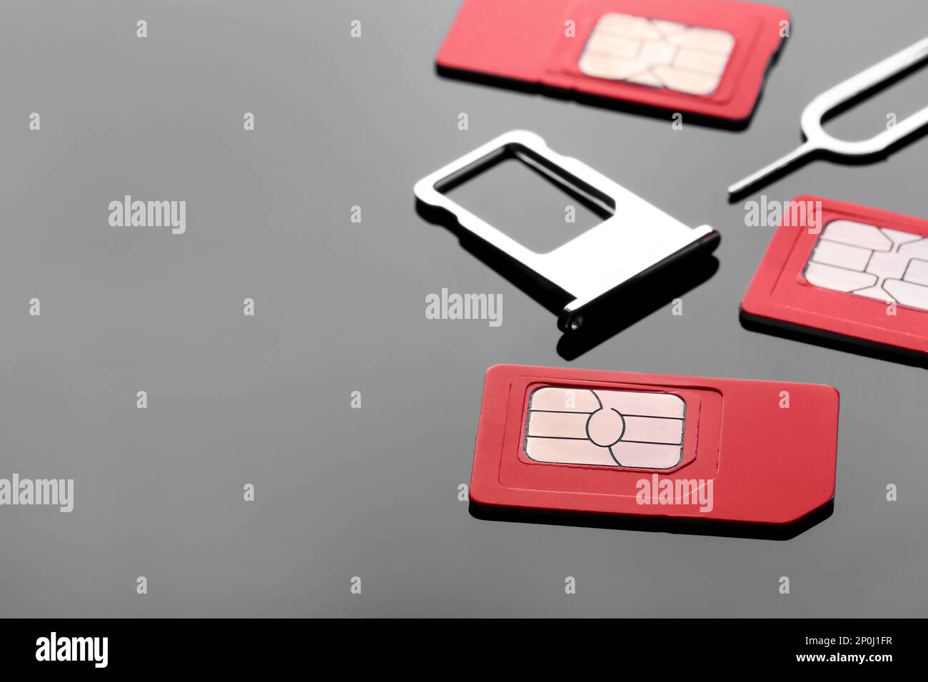 SIM-Karten, Einschub und Auswerfer auf grauem Hintergrund. Platz für Text Stockfoto