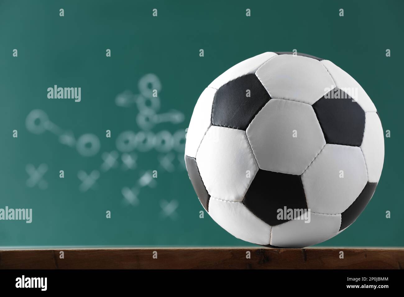 Football-Ball gegen unscharfe Spielpläne. Platz für Text Stockfoto