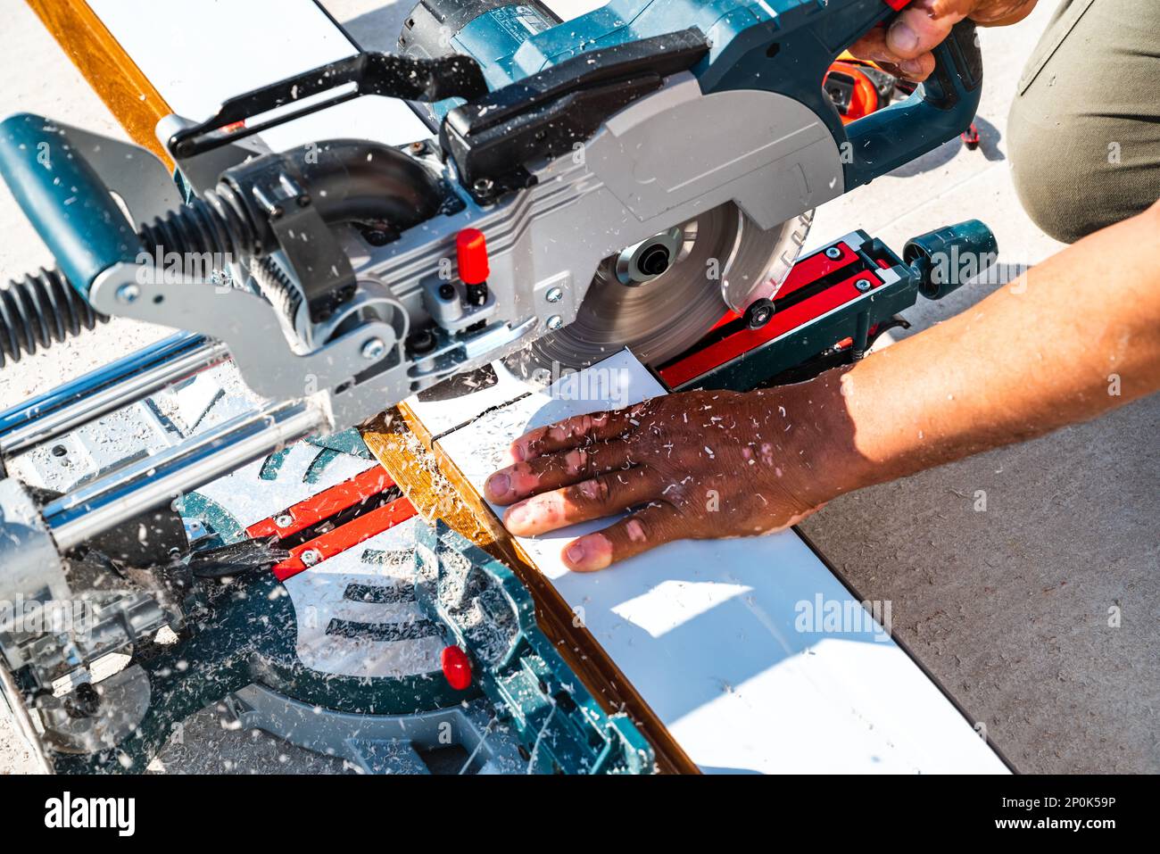 Gehrungssäge. Schneiden von Dielen aus Verbundwerkstoff. Späne Stockfoto