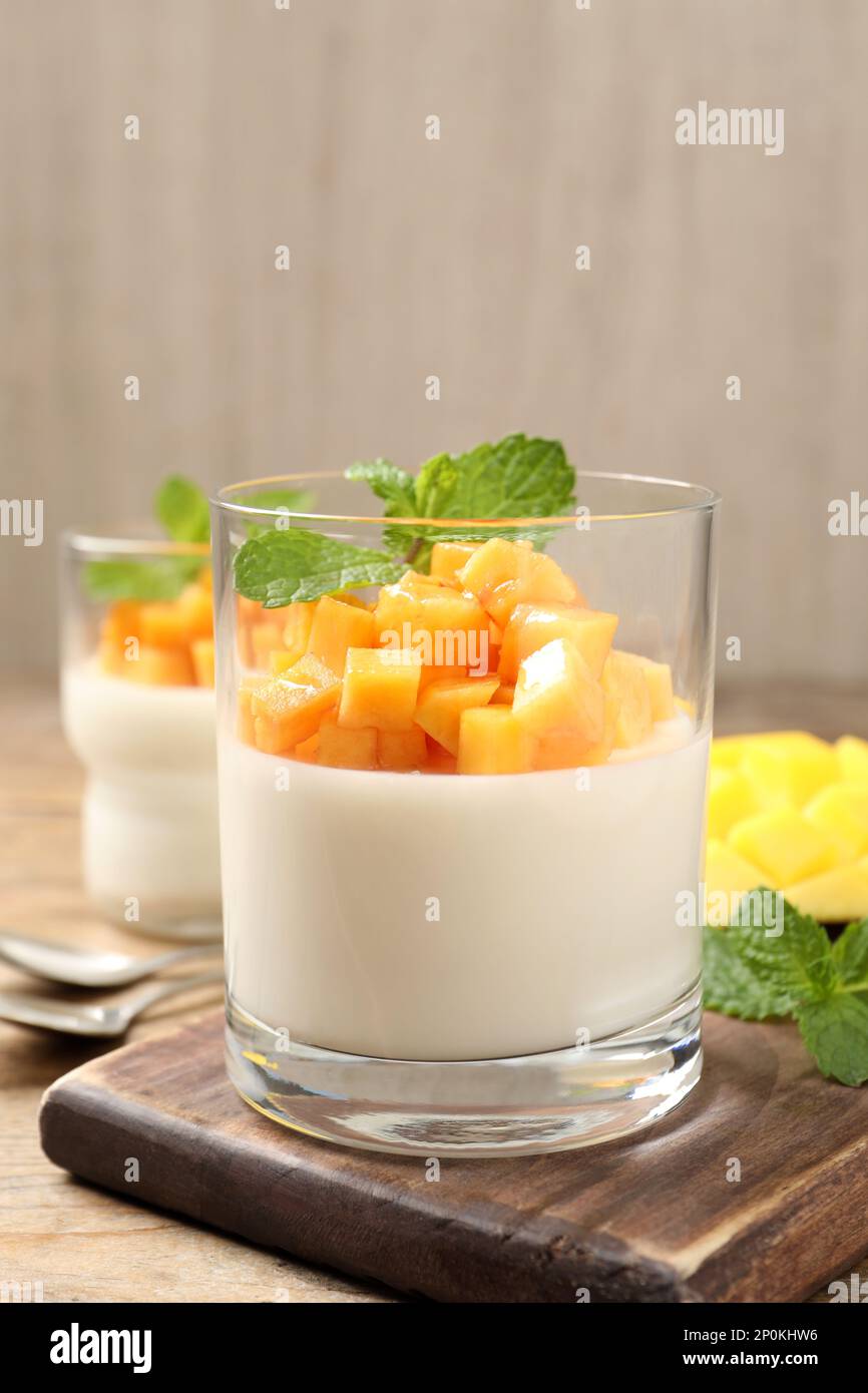 Köstliches Panna Cotta mit Mango auf einem Holztisch Stockfoto