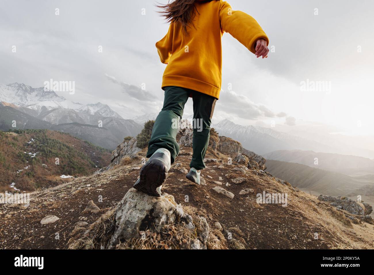 Sportliches junges Mädchen liegt in den Bergen hoch. Konzept des aktiven Tourismus Stockfoto