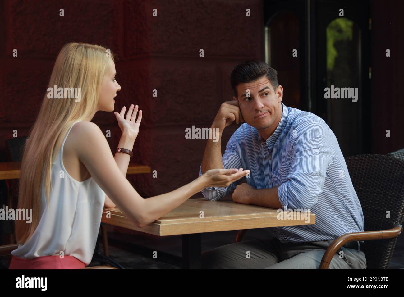 Ein Mann hat ein langweiliges Date mit einer gesprächigen Frau im Café Stockfoto