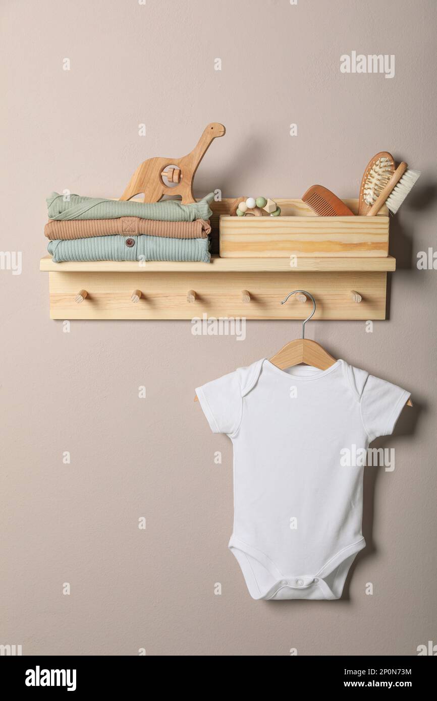 Babykleidung, Spielzeug und Accessoires auf einem Holzständer Stockfoto