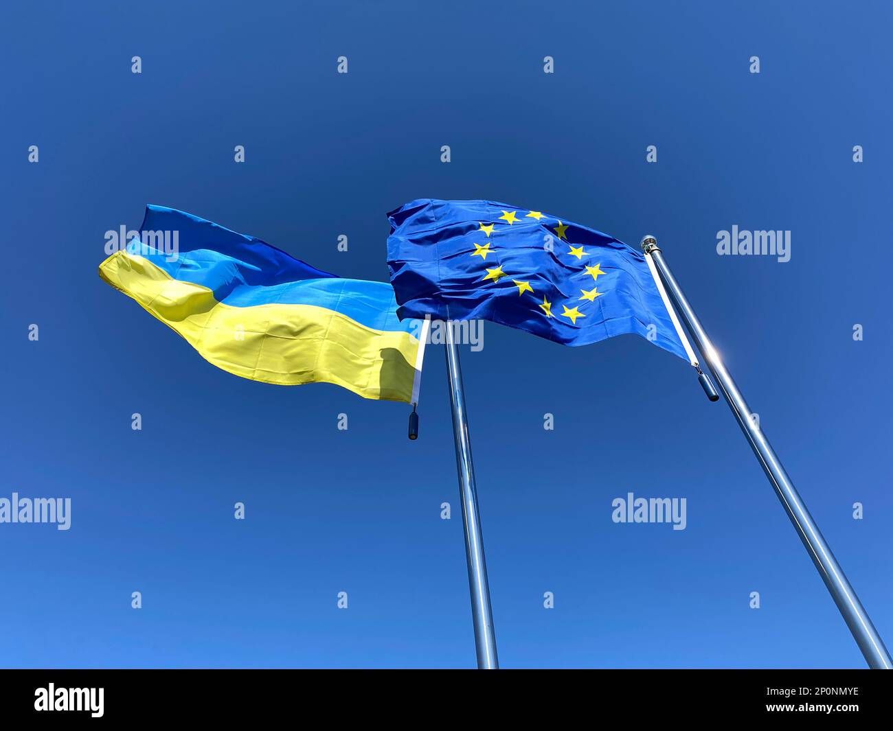 Flaggen der Ukraine und der Europäischen Union auf Flaggen vor blauem Himmel Stockfoto