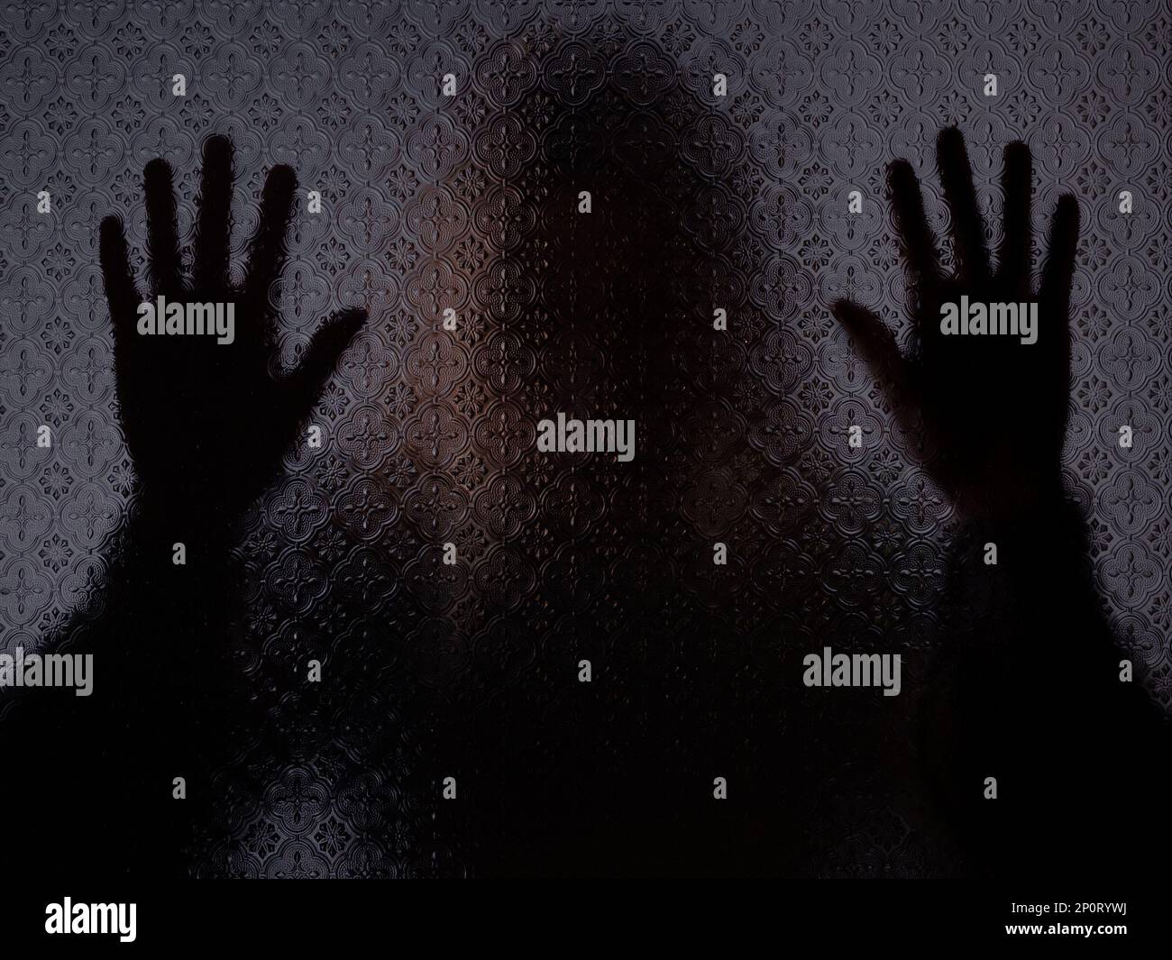 Verschwommene Silhouette einer geheimnisvollen Frau, die hinter Milchglas steht, mit beiden Händen gegen das Glas. Konzept der Hilfeanfrage Stockfoto