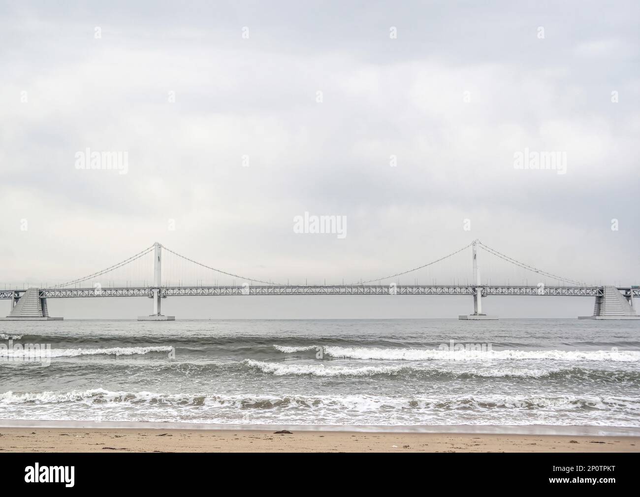 Busan, Südkorea - Mai 2019: Gwangandaegyo oder Diamond Bridge, Hängebrücke Foto vom Strand der Stadt Busan an an einem windigen Tag mit Wellen Stockfoto
