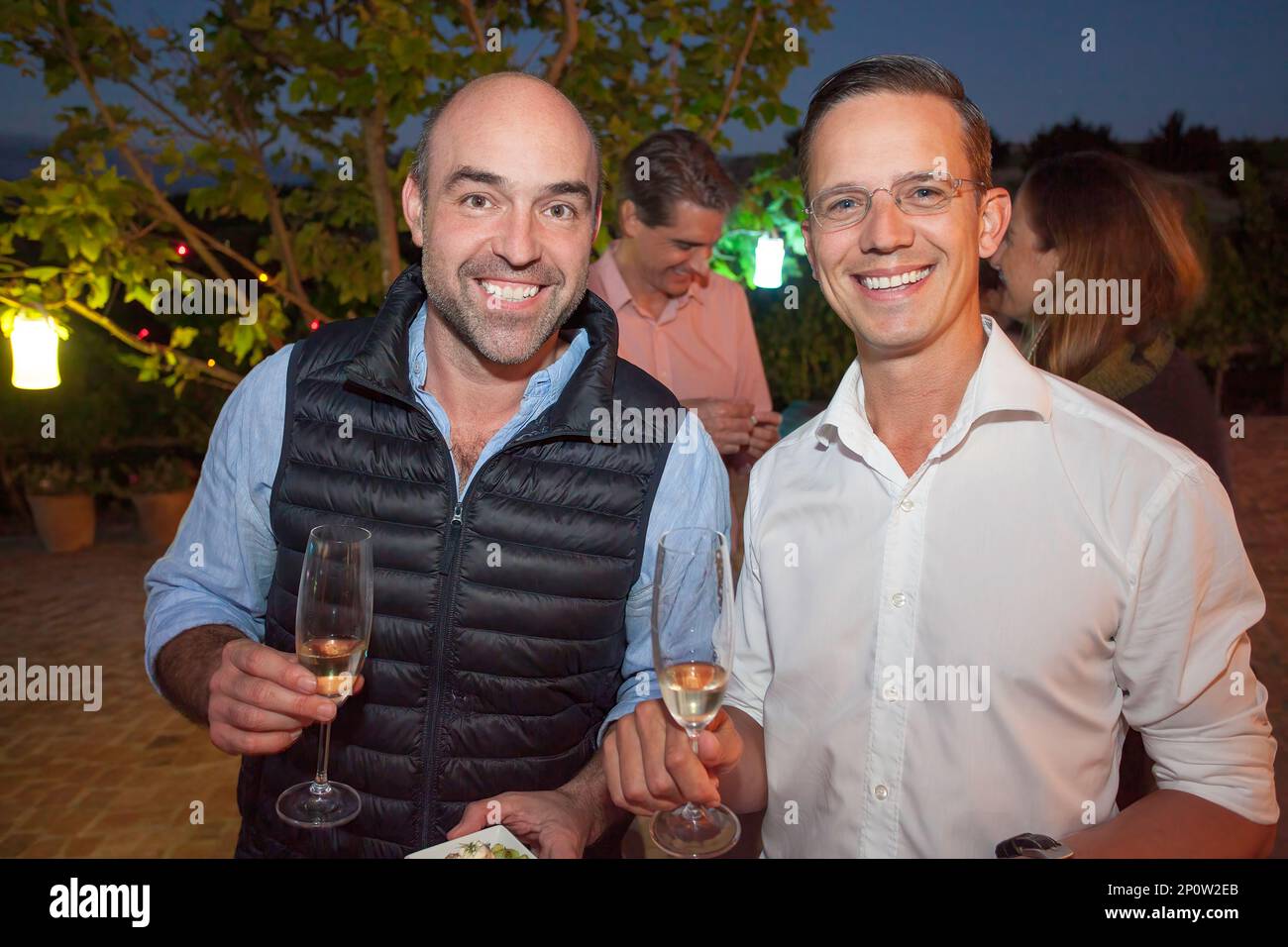 Zwei Männer halten Champagner und lächeln Stockfoto
