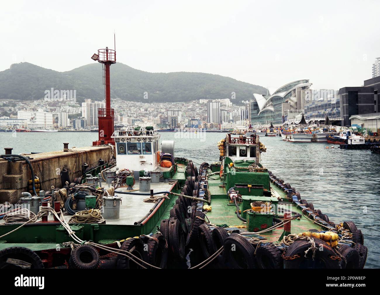 Busan, Südkorea - Mai 2019: Hafen von Busan und alte Fischerboote sowie bewölkte Stadtlandschaft und Landschaft Stockfoto