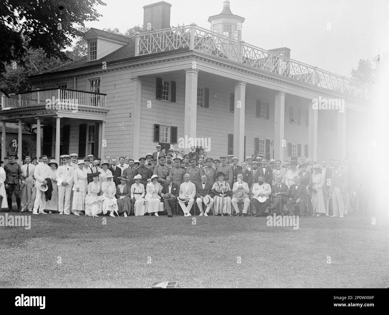 Gruppe in Mount Vernon, 24. Juni 1917. Eine große Gruppe belgischer und russischer Kriegsmissionsmitglieder, US-Militäroffiziere, zwei Kabinettsmitglieder und mehrere Mitglieder der Mount Vernon Ladies Association stellten sich vor Mount Vernon. Erste Reihe, von links nach rechts, beginnend mit Frau mit weißem Hut und dunklem Sonnenschirm: Jane Riggs, Margaret Wilson, Baron Ludovic Moncheur, Robert Lansing, russischer Botschafter Boris Bakhmetev, Addie Werth Bagley Daniels und Josephus Daniels; mittlere Reihe, von links nach rechts, beginnend mit Mann in Militäruniform: Oberst Oranovsky, General Leclercq, Major Leon Osterrieth, Brig. General Joseph E. Stockfoto