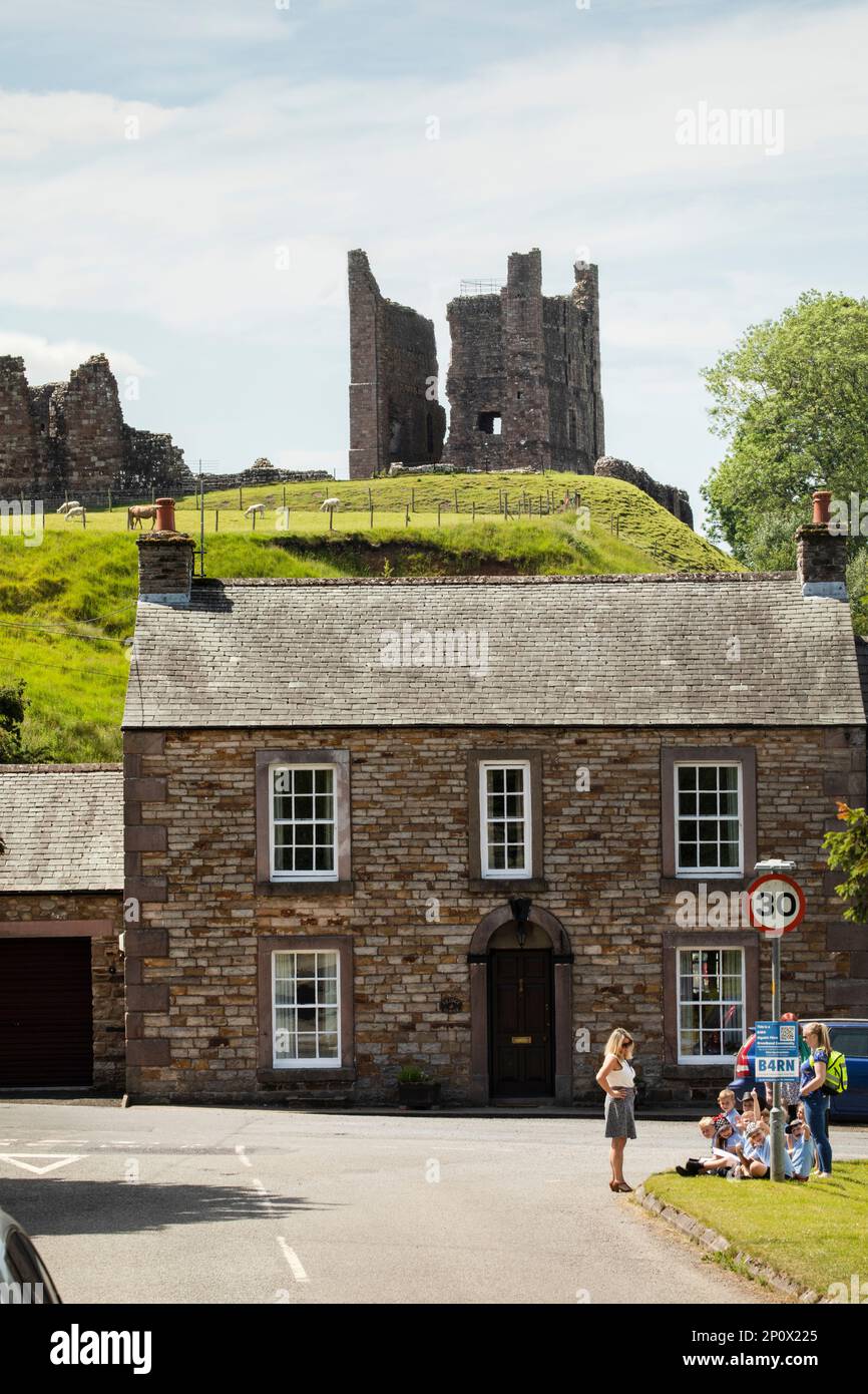 Eine Gruppe von Schulkindern und ihren Lehrern sitzen auf dem Rasen in der Nähe von Brough Castle, Cumbria Stockfoto