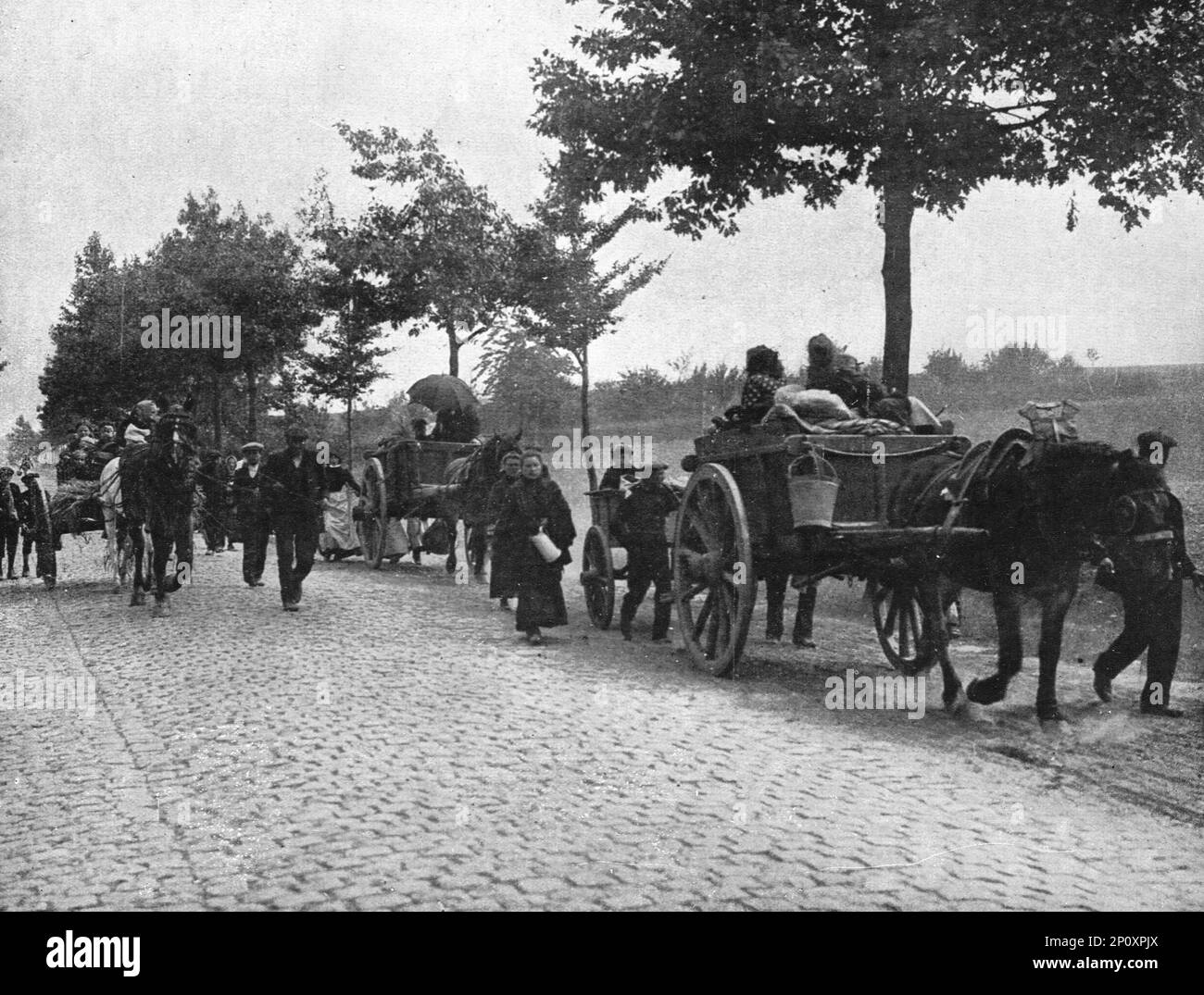 "Devant l'envahisseur; Les habitants des campagnes belges, emportant ce qu'ils ont pu reunir dans la hate de la panique, fuient sur les Routes", 1914. Aus „L'Album de la Guerre 1914-1919, Volume I“ [L'Illustration, Paris, 1924]. Stockfoto