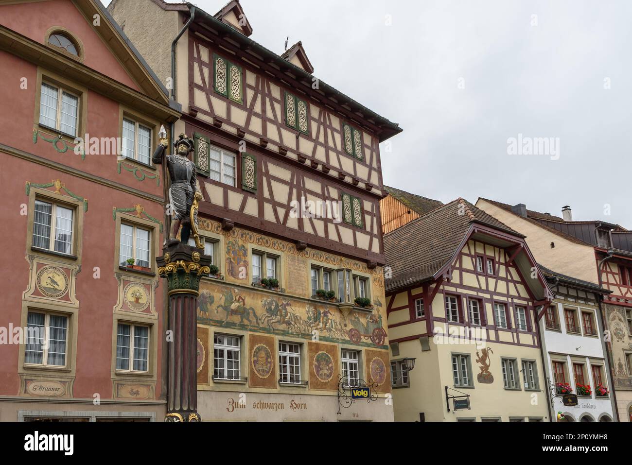 Skulpturen auf Brunnen und Fachwerkhäusern mit Fassadenmalereien in der mittelalterlichen Altstadt von Stein am Rhein, Kanton Schaffhausen, Schweiz Stockfoto
