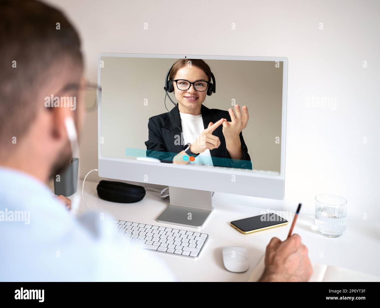 Ein Mann führt ein Videogespräch mit einer Lehrerin, die E-Learning-Kurse im Online-Coaching absolviert. Stockfoto