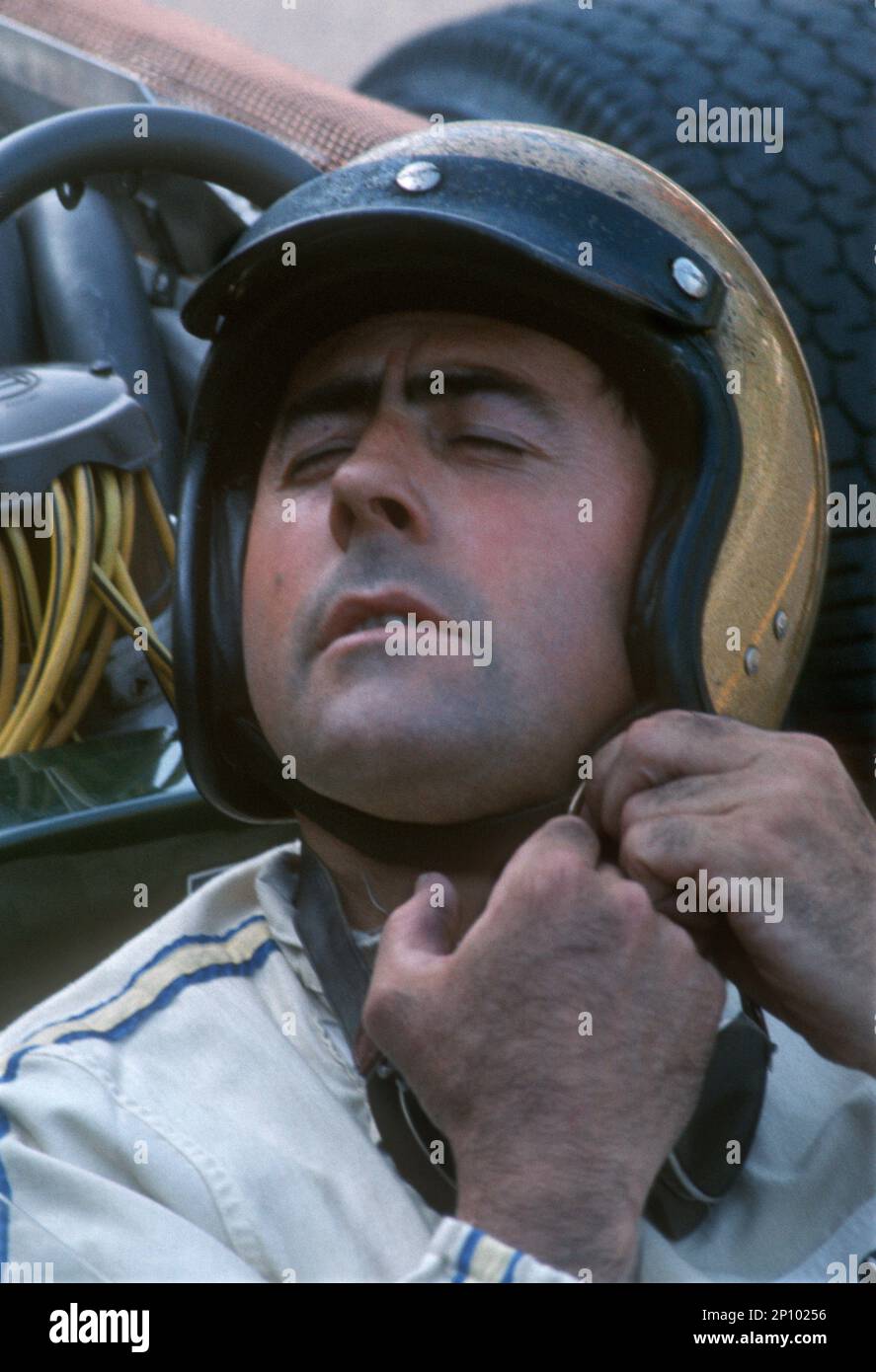 Australischer Fahrer Jack Brabham, dreifacher Formel-1-Weltmeister (1959, '60 & '66), der Helm bindet. Vorbereitung auf den Start beim Großen Preis von Belgien im Spa Fr. Stockfoto