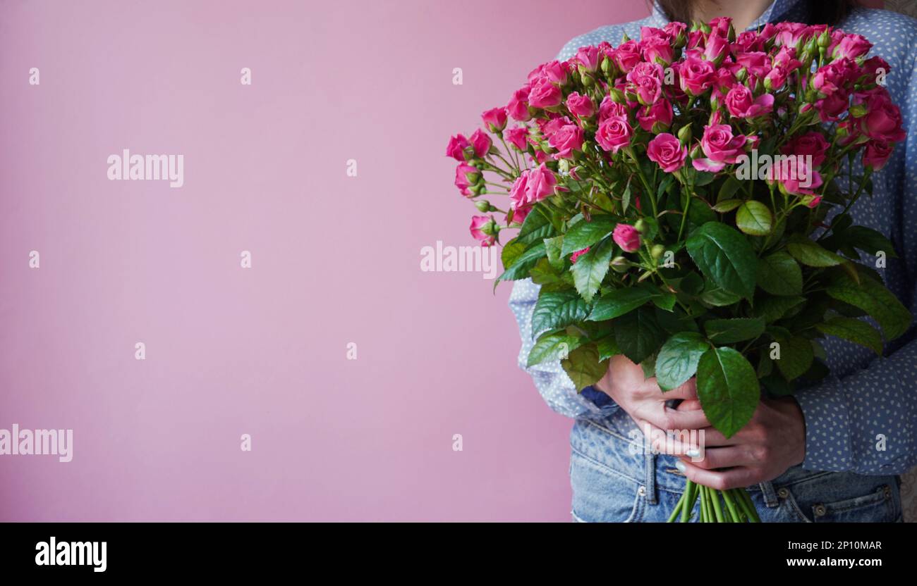 International Women's Day.Konzept des Grußbanners für den internationalen Frauentag am 8. März.Nahaufnahme Frauenhände mit großem Blumenstrauß rosa Rosen o Stockfoto